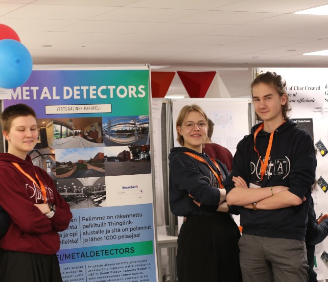 Metal Detectors -työn kehittänyt nelikko posterinsa äärellä Otaniemen lukion aulassa.