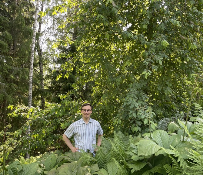 Teppo Manninen seisoo luonnon vihreyden keskellä.