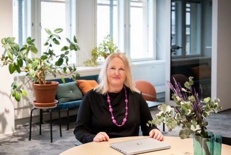 TEKin HR-johtaja Kati Johansson kuvattuna TEKin toimistolla pöydän ääressä