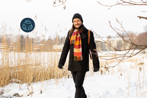 Jussi-Pekka Teini walks outdoors past a snowy bed of reeds.