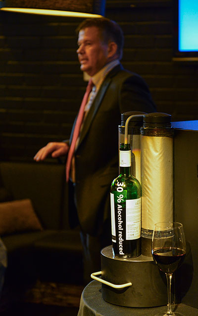 Winemill-startupille rakennettu protolaite poistaa 20-50 % viinin sisältämästä alkoholista. Taustalla yrityksen perustaja Sami Gauffin esittelee innovaatiota.