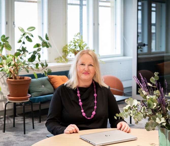 TEKin HR-johtaja Kati Johansson kuvattuna TEKin toimistolla pöydän ääressä