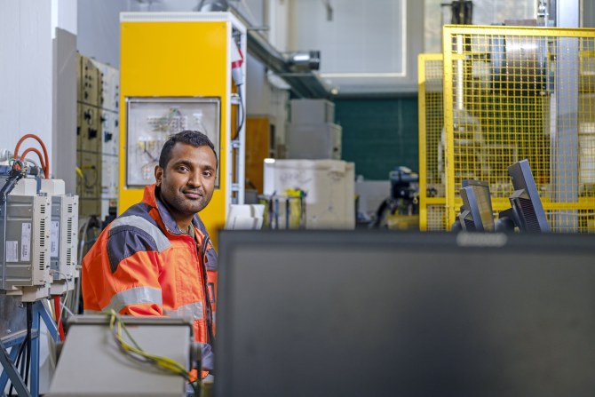 F. M. Mahafugur Rahman sähkötyötilassa päällään oranssi työtakki.