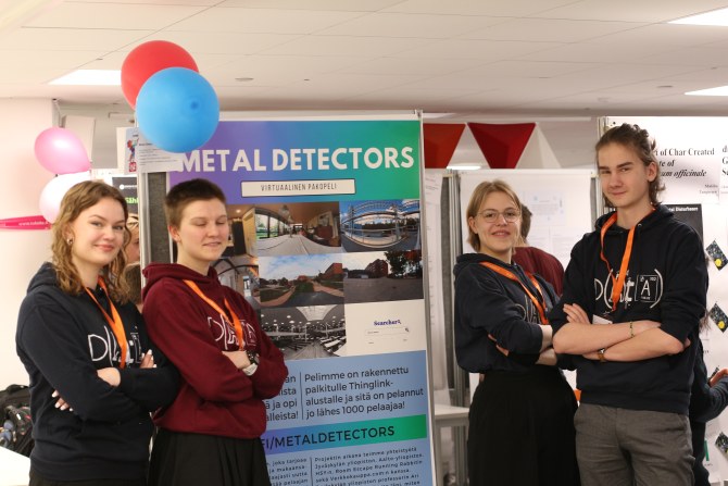 Metal Detectors -työn kehittänyt nelikko posterinsa äärellä Otaniemen lukion aulassa.