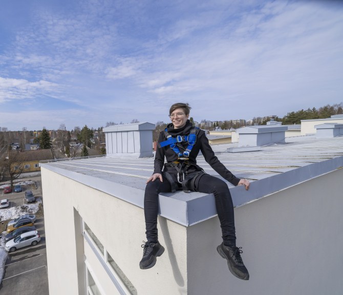 Mirika Knuutila istuu rakennuksen katolla.
