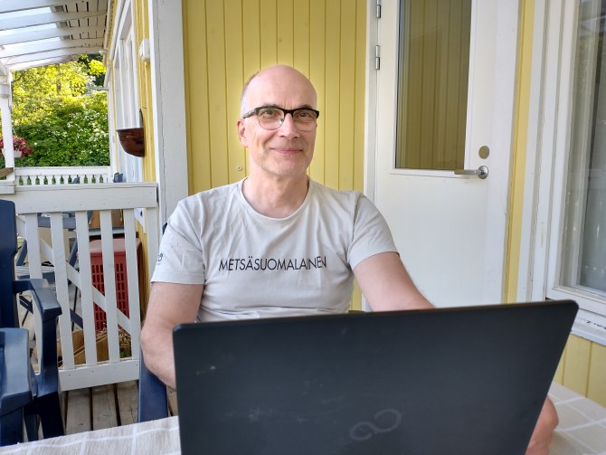 Kyösti Huhtala istuu tietokoneen takana.