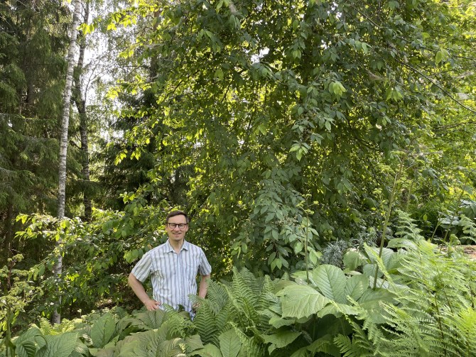 Teppo Manninen seisoo luonnon vihreyden keskellä.