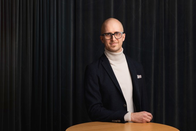 Jussi Aaltonen henkilökuvassa tumman verhon edessä.
