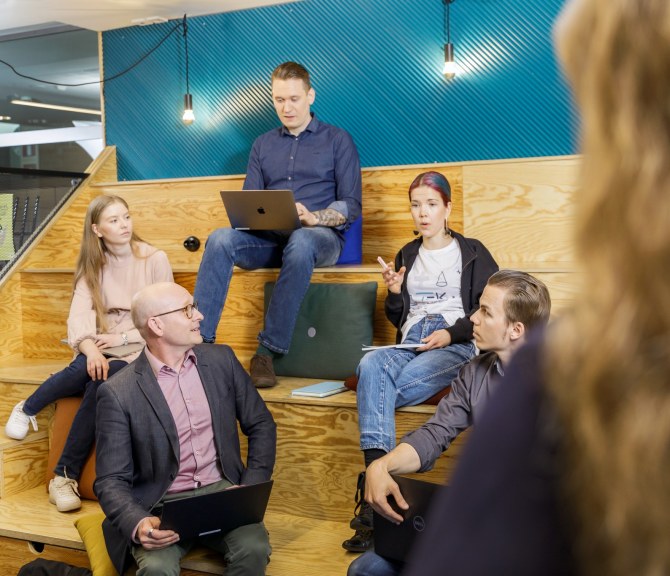 Henkilöitä istuu TEK Loungen katsomossa Tampereella.