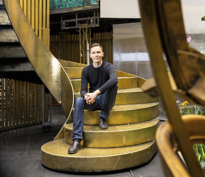 Mikko Par­viainen istuu kultaisilla portailla Oopperatalossa.