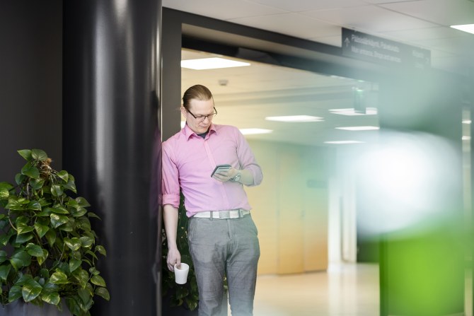 Opiskelija katsoo kännykkäänsä