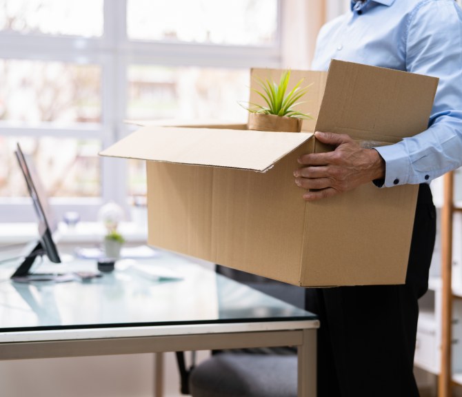 Irtisanottu kantaa pahvilaatikkoa.