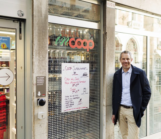 Jarno Martikainen katsoo kameraan kaupan edessä.