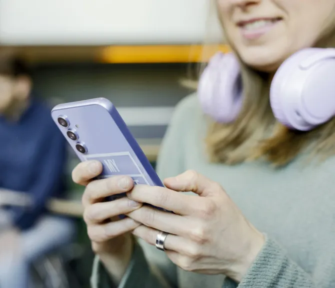 Lähikuvassa henkilö lukee puhelimeltaan jotain.