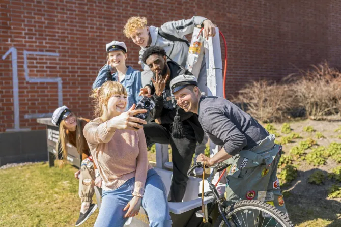 Opiskelijaporukka ottaa selfietä.