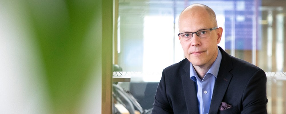 Teemu Hankamäki istuu pöydän ääressä.
