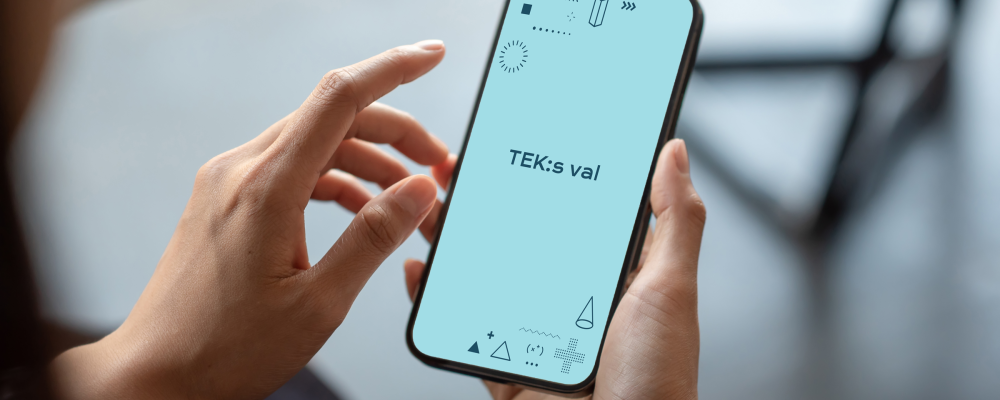 Henkilöllä on kädessä puhelin, jonka näytöllä lukee TEK:s val.