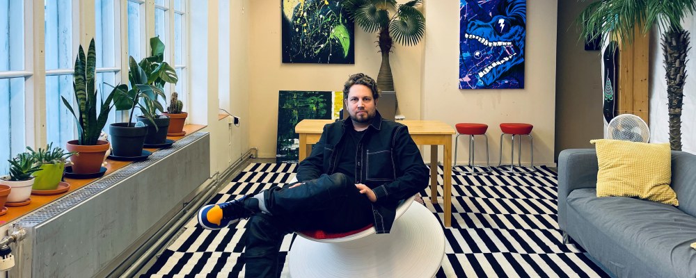 Arkkitehti Ville Saarikoski istuu värikkäässä studiossaan.