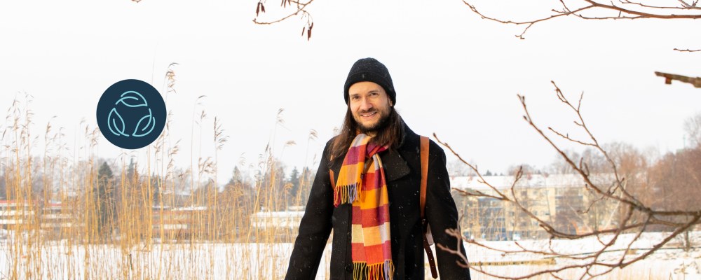 Jussi-Pekka Teini kävelee lumista polkua kaislikon ohi.