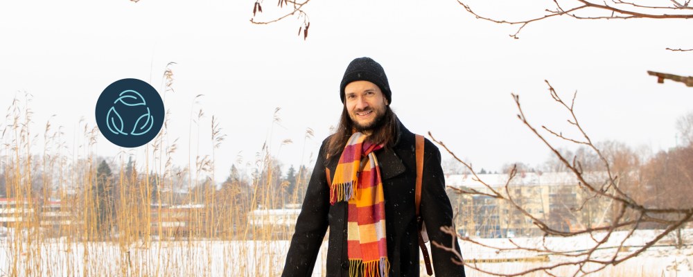 Jussi-Pekka Teini walks outdoors past a snowy bed of reeds.