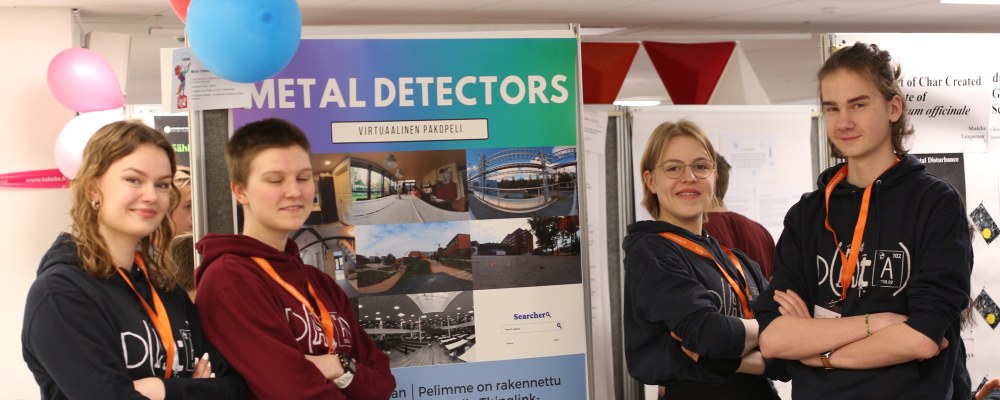 Metal Detectors -työn kehittänyt nelikko posterinsa äärellä Otaniemen lukion aulassa.