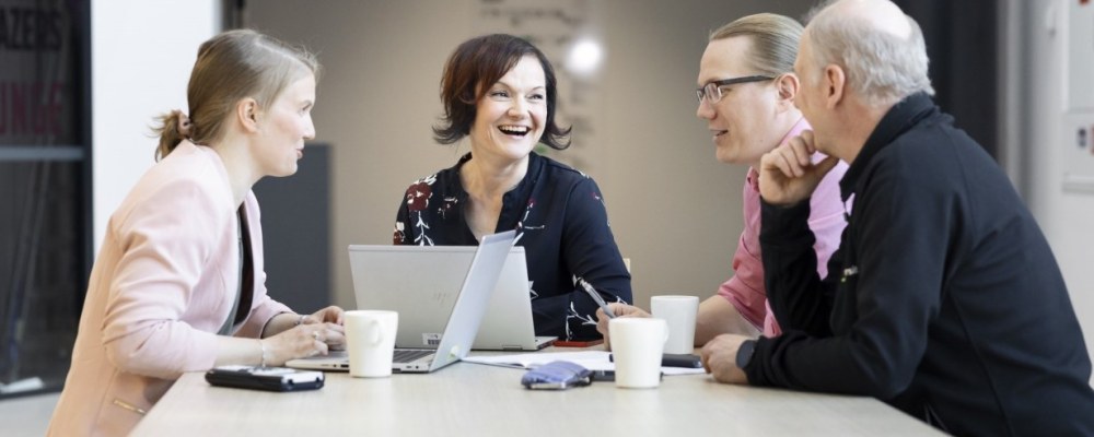 Ihmisiä pöydän äärellä