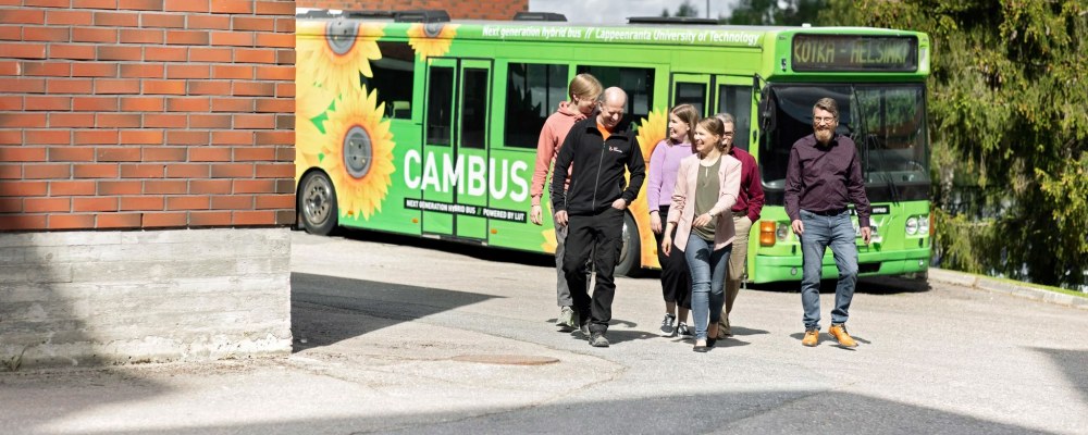 Ihmisiä kävelemässä LUT-yliopiston pihalla Lappeenrannassa, takana bussi.