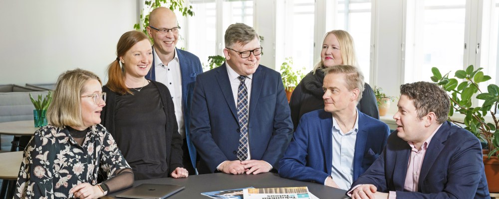 Johtoryhmä pöydän ääressä