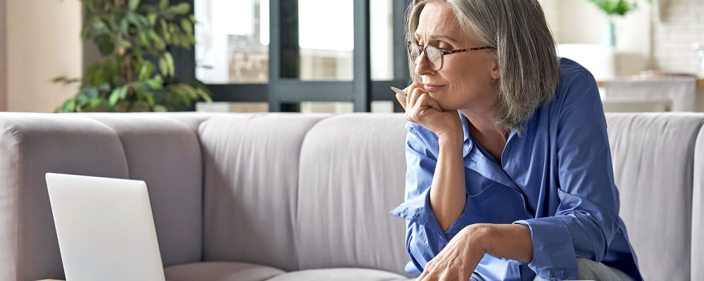 Nainen istuu tietokoneen äärellä