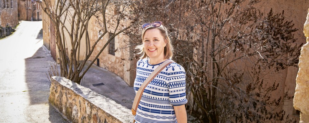 Julia Ahvenainen istuu matalalla muurilla.