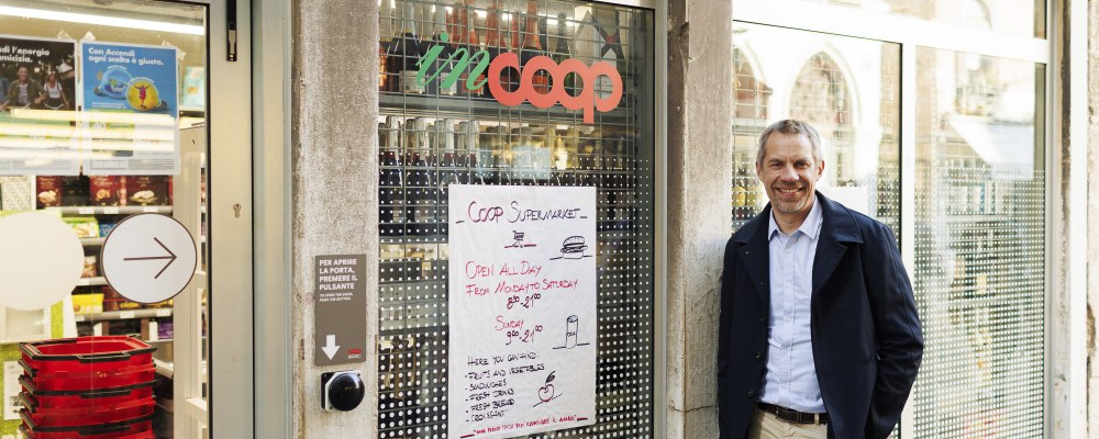 Jarno Martikainen katsoo kameraan kaupan edessä.