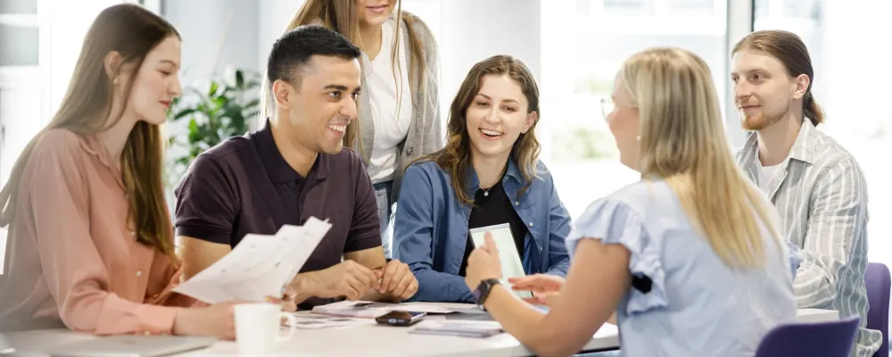 iloiset ihmiset juttelevat pöydän äärellä