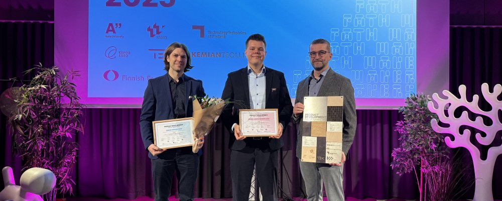 Voittajia palkintojen kanssa lavalla.