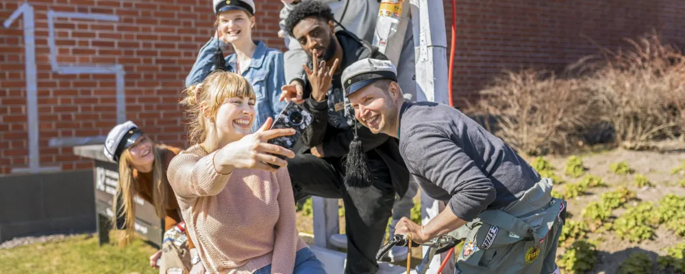Opiskelijaporukka ottaa selfietä.