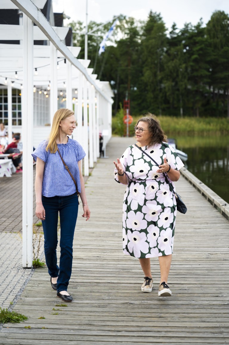 kaksi henkilöä kävelee ja keskustelee