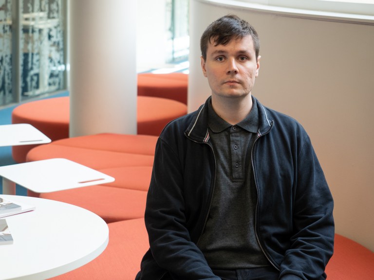 TEKin ja TFiFin diplomityöpalkittu Jaakko Marin kuvattuna istumassa punaisella sohvalla Tampereen yliopistolla.