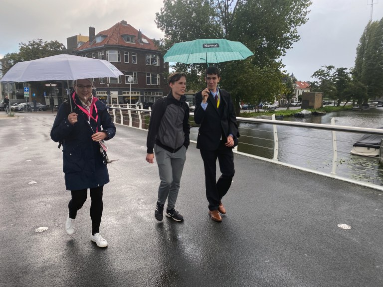 Yhteiskuntaopin lehtori Anni Kinttu, Miro Keimiöniemi ja Adam Yousfi kävelevät sateisessa Leidenissä.