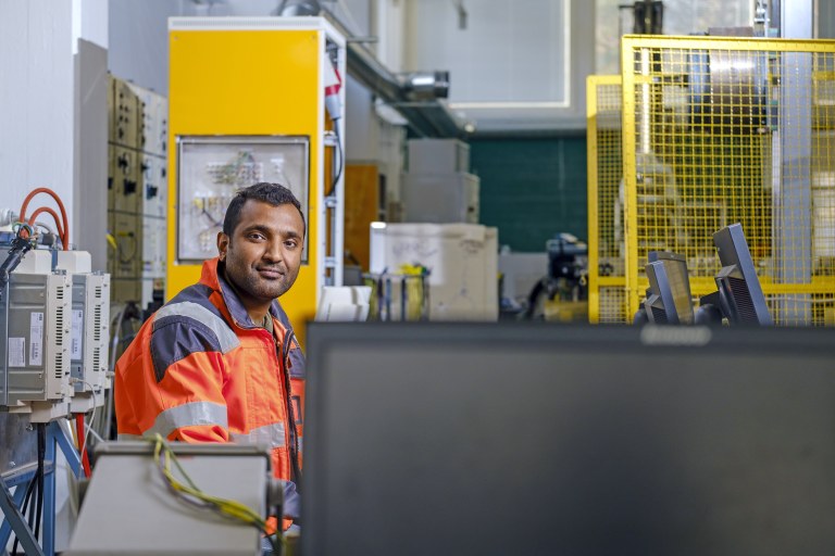 F. M. Mahafugur Rahman sähkötyötilassa päällään oranssi työtakki.