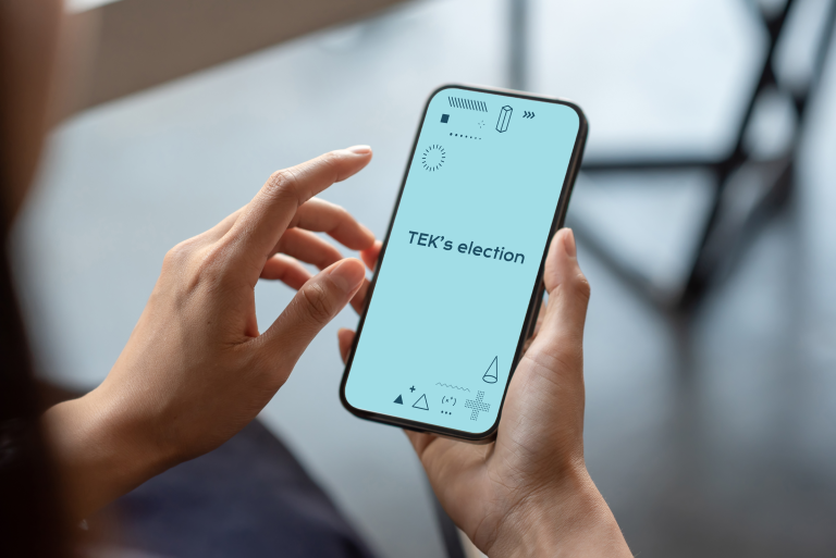 Henkilöllä on kädessä puhelin, jonka näytöllä lukee TEK's election.