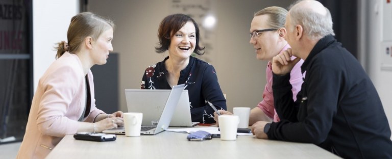 Ihmisiä pöydän äärellä