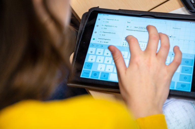 Nuori tekee matematiikan tehtäviä tablettitietokoneella