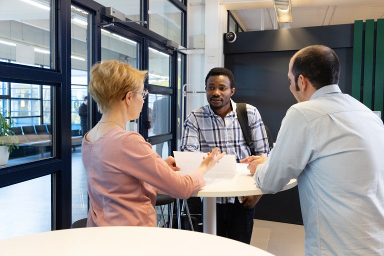 Kolme henkilöä keskustelee.