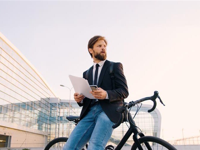 henkilo pyörän päällä asiakirjat käsissä