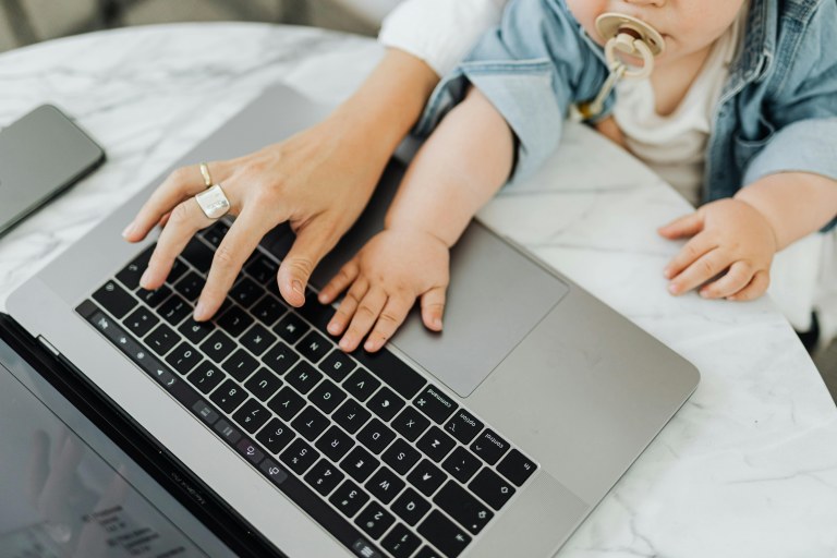 Aikuinen ja vauva yhdessä kannettavan tietokoneen äärellä