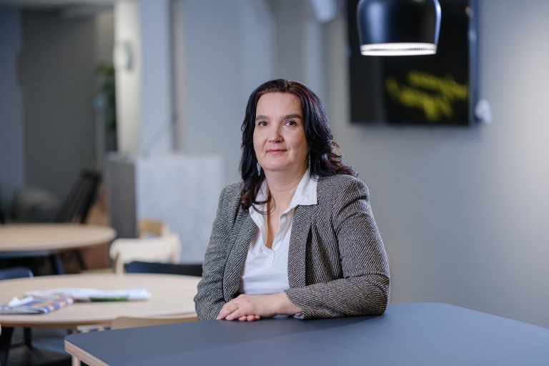 Susanna Bairoh istuu pöydän ääressä.