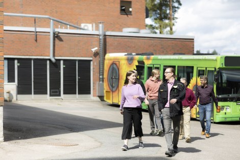 Henkilöitä kävelee ulos bussista.