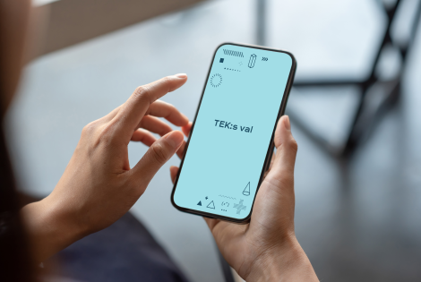 Henkilöllä on kädessä puhelin, jonka näytöllä lukee TEK:s val.
