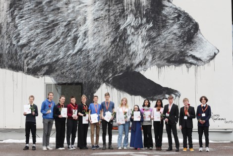 Winners of the TuKoKe 2023 Competition, behind them a wall painting of a bear.