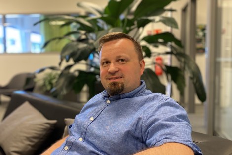 Timo Välikangas istuu mustalla sohvalla toimistotilassa.