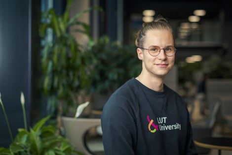 Niilo Hendolin yllään LUT-yliopiston paita, taustalla huonekasveja.